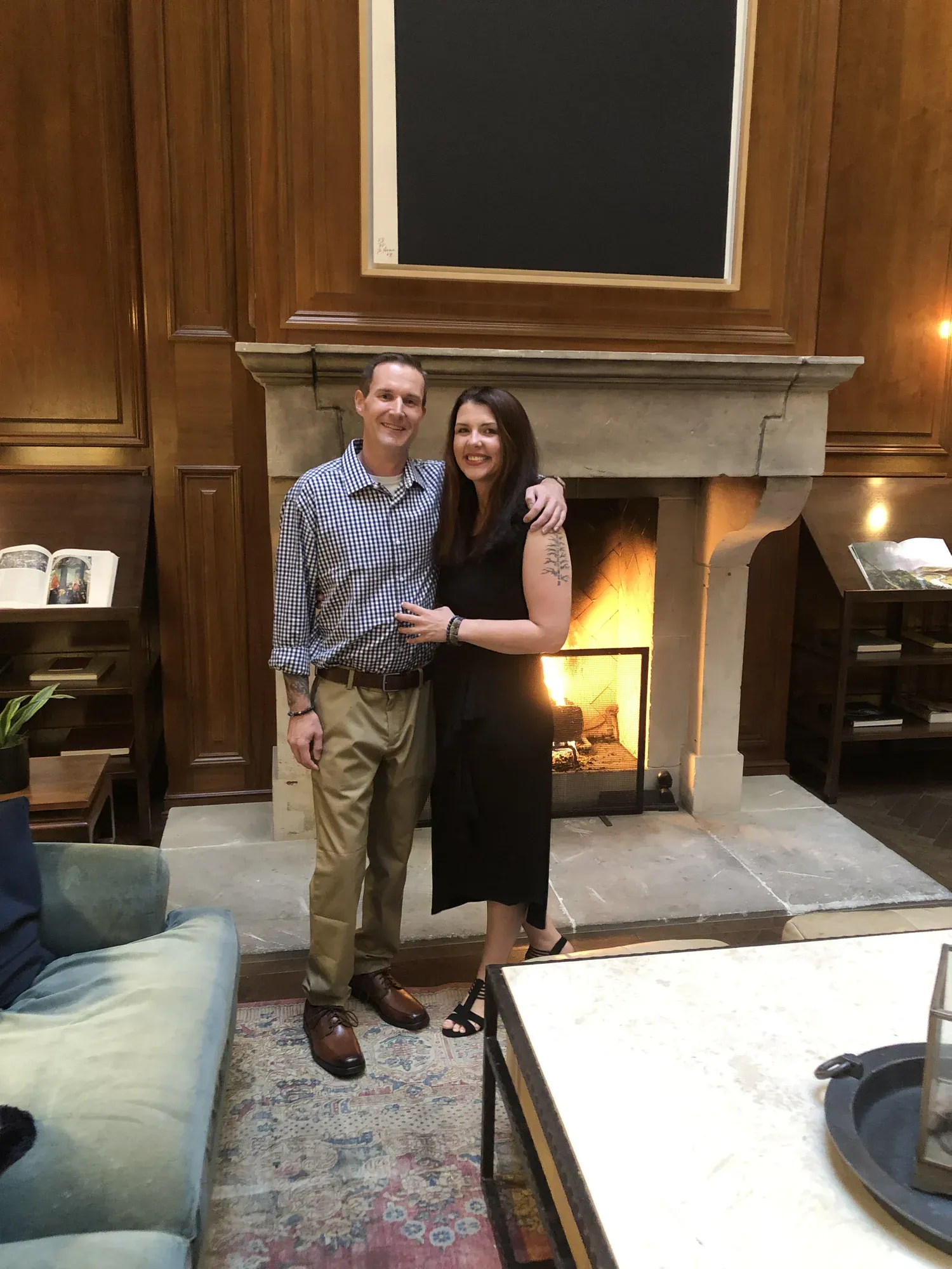 Bryan and his wife in front of a lit fireplace